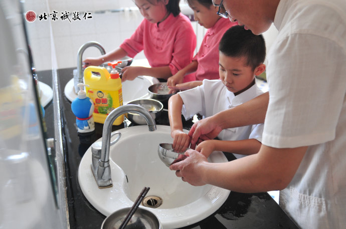 生活老师指导小学员清洁餐具