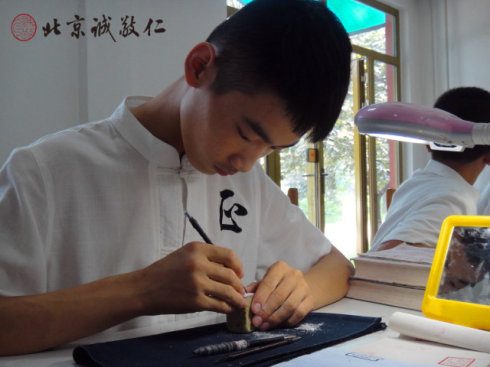 
篆刻班小学员在认真专注的习练篆刻
