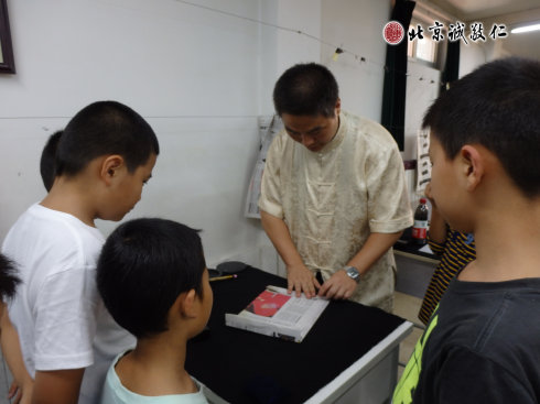 书法老师指导学员学习书写纸张的标准规范