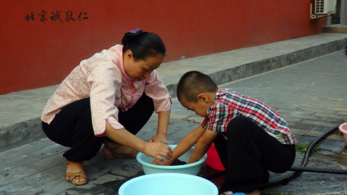 生活老师指导小学员洗衣服