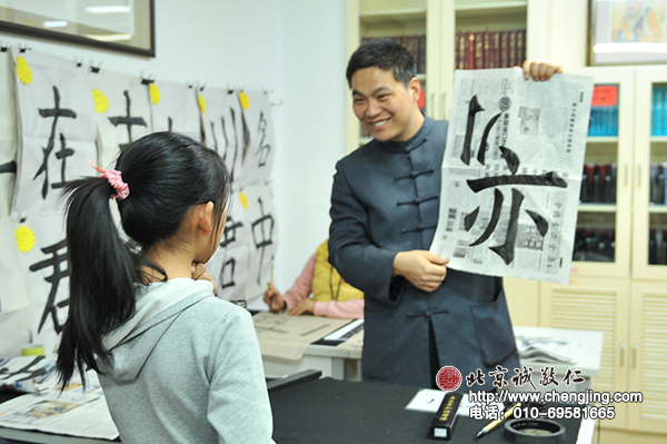 郑老师欣喜的收获小学员的习作成果，并予以指导。